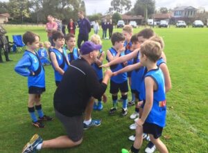 Man talking to young players.