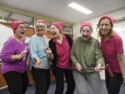 Four ladies singing wearing pink.