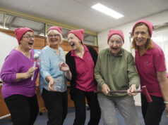 Four ladies singing wearing pink.