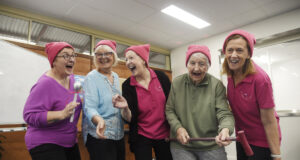 Four ladies singing wearing pink.