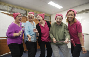 Four ladies singing wearing pink.