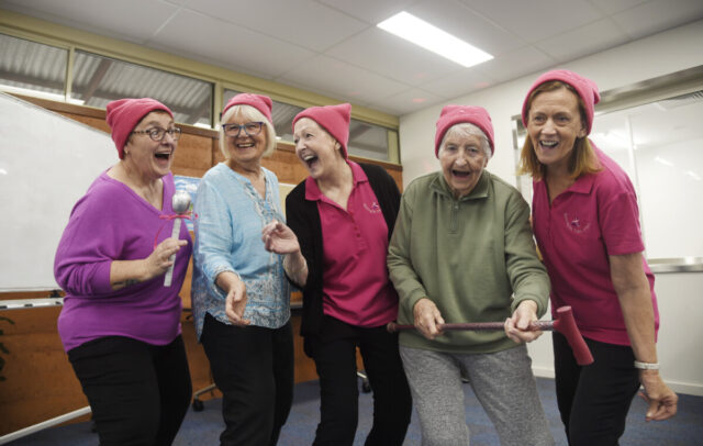 Four ladies singing wearing pink.