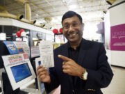 Man pointing at lotto ticket.