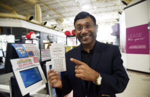 Man pointing at lotto ticket.