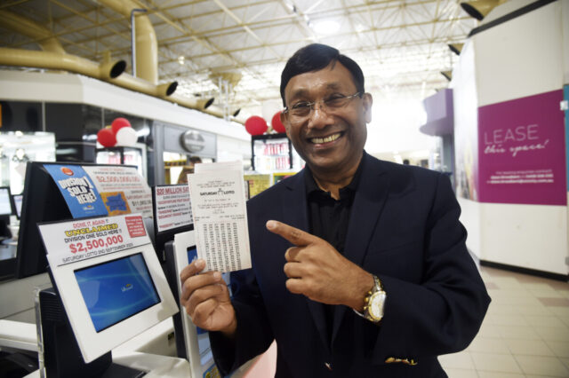 Man pointing at lotto ticket.