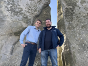 Two men pose for photo at Stonehenge.