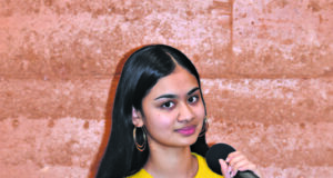 Women in a yellow shirt holding a mic.