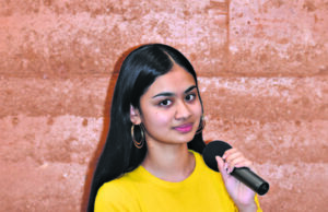 Women in a yellow shirt holding a mic.