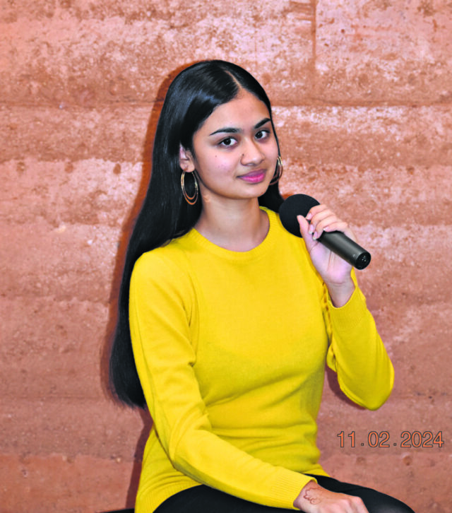 Women in a yellow shirt holding a mic.