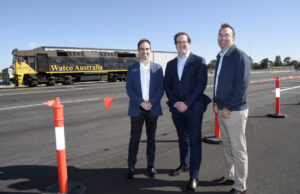 3 men standing in front of a freight train