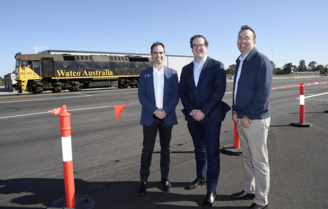 3 men standing in front of a freight train