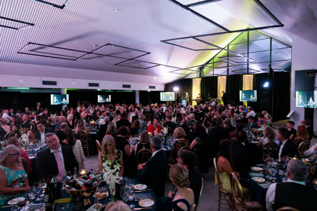 Wide shot of the crowd and tables at the Charity Gala Dinner.